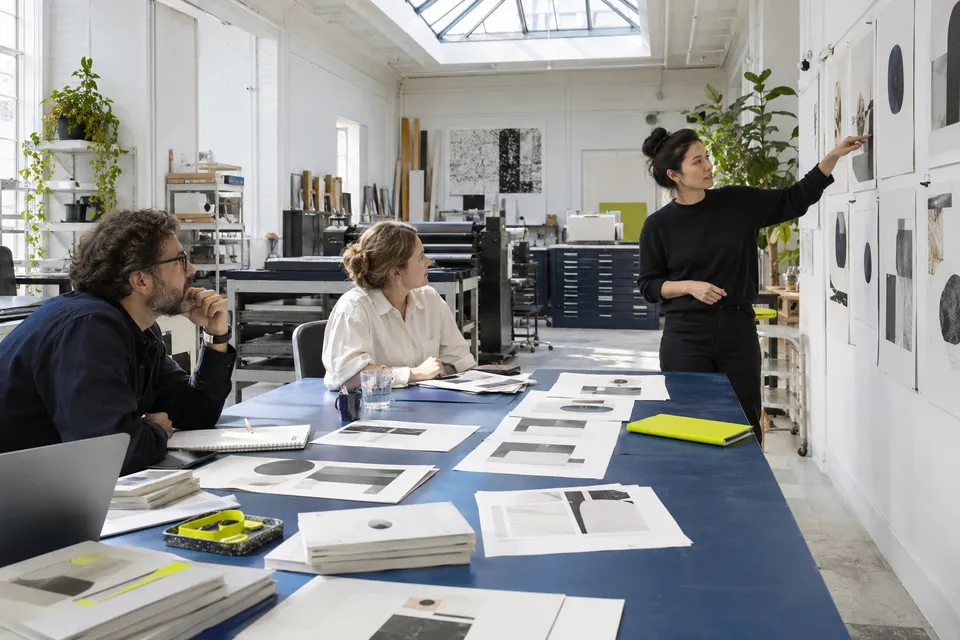 Adults reviewing printed page proofs together
