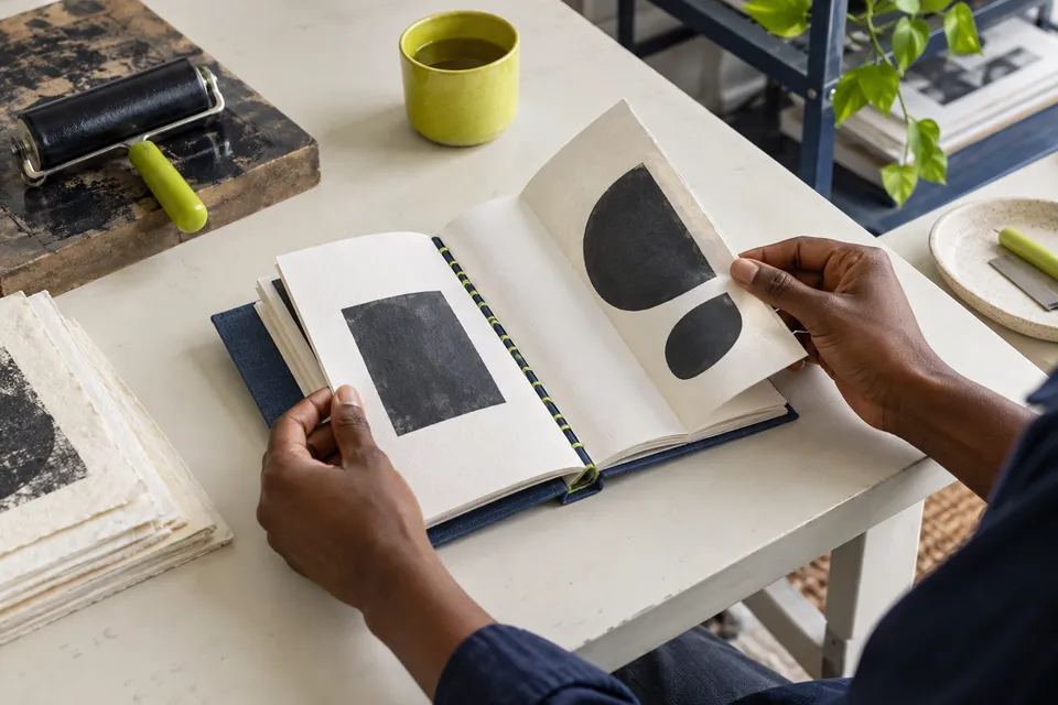 Hands turning the pages of a handbound publication